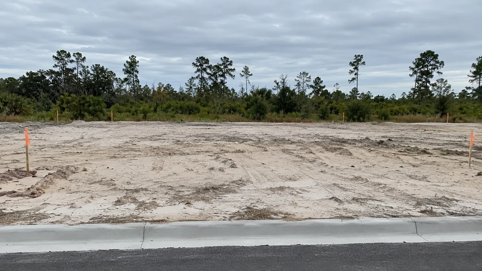 Solar vacío con estacas de replanteo en una urbanización nueva de Florida